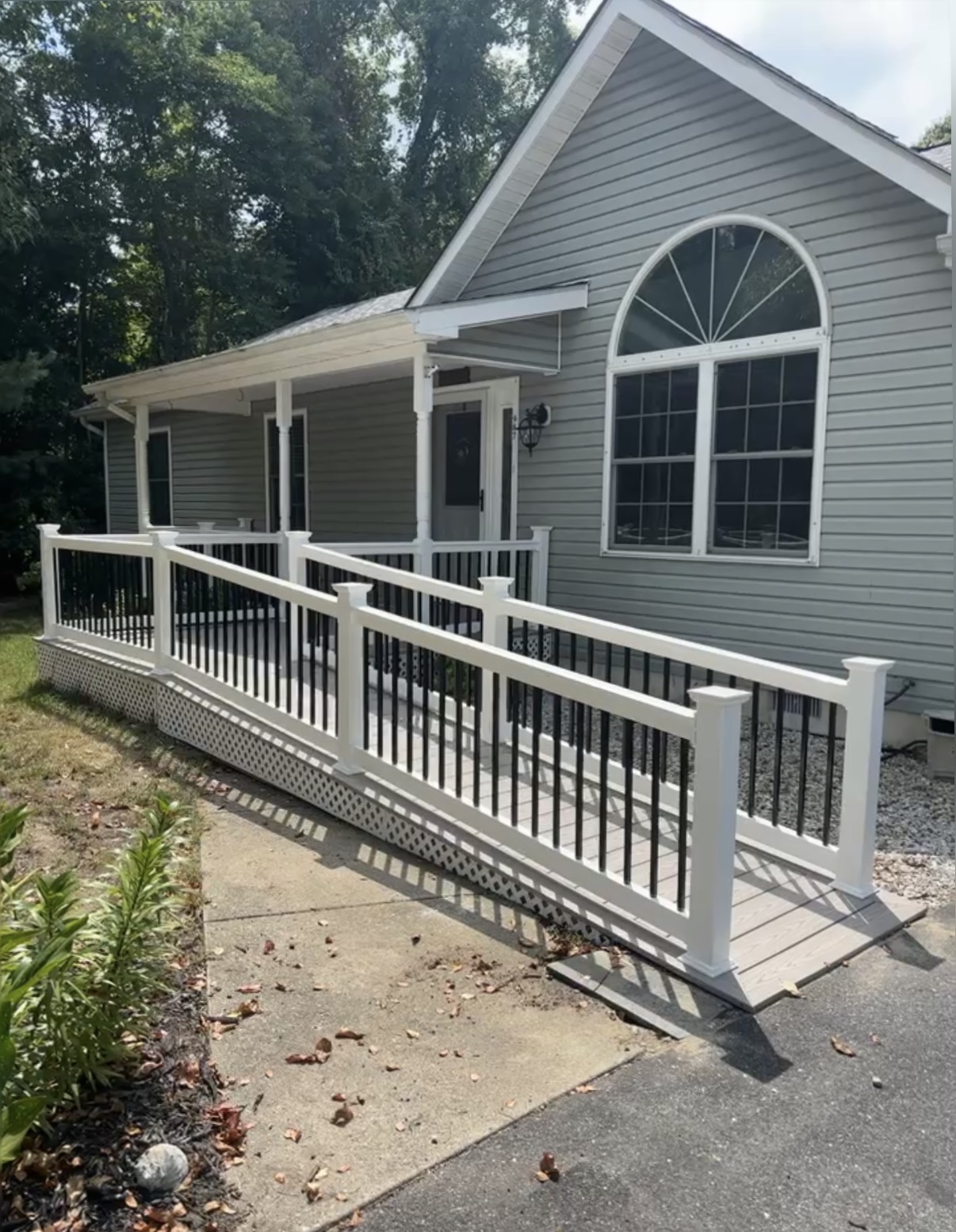Side view of the ramp showing gentle ADA-friendly slope, white railings and lattice skirt