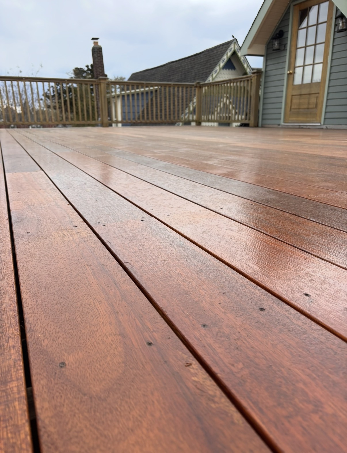 Close-up of the wet mahogany deck boards showing rich grain and tight reveals