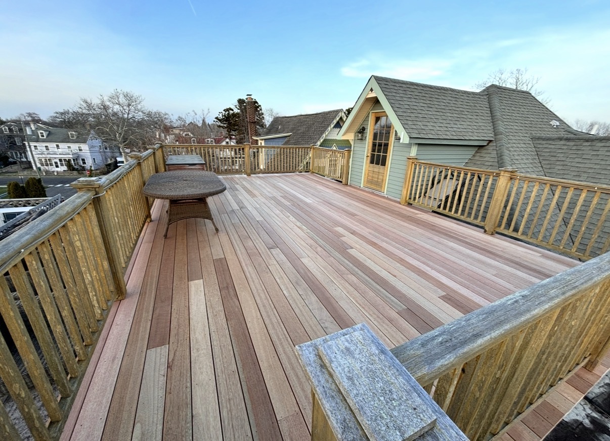Wide view of the finished mahogany rooftop deck at golden hour