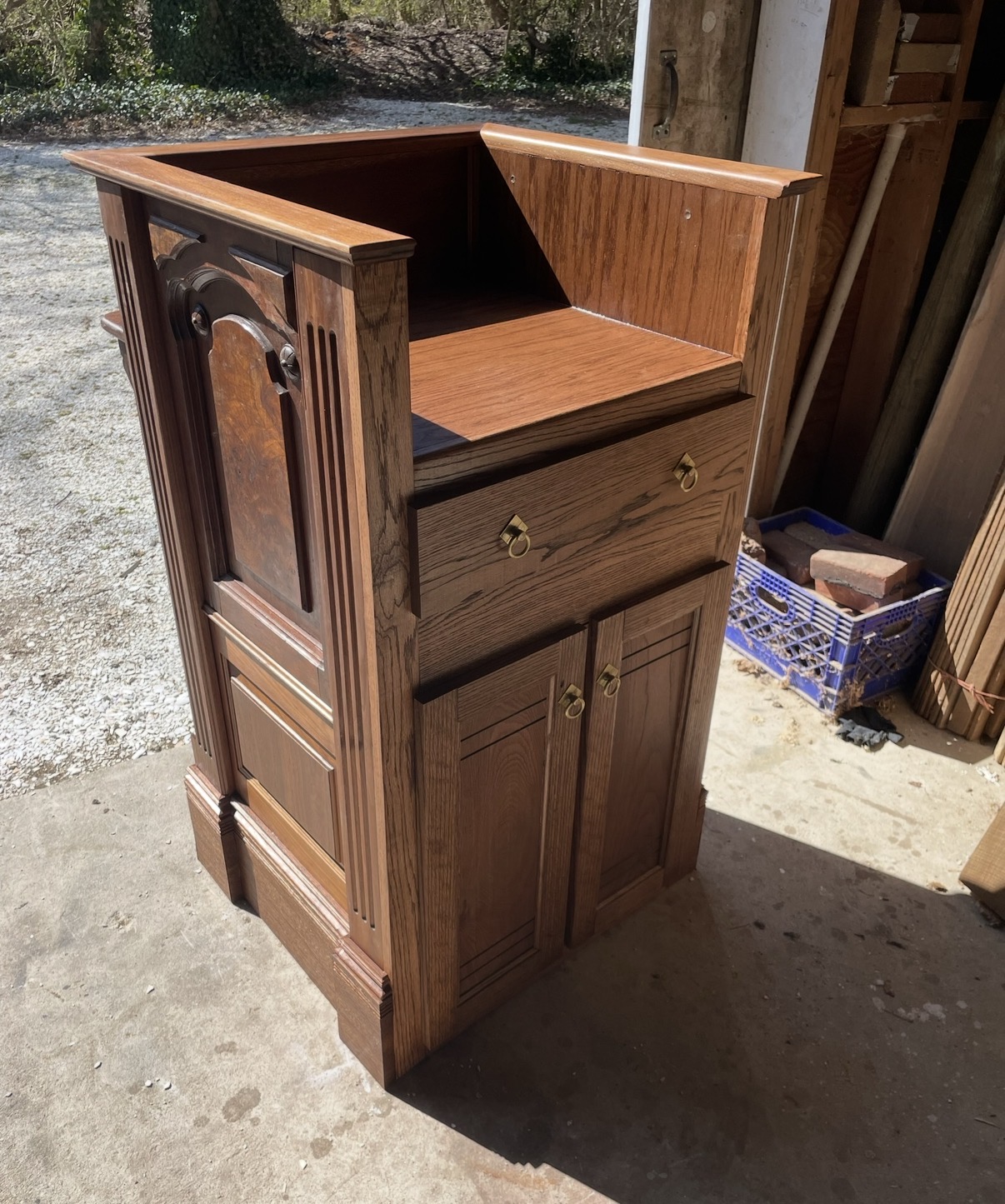 Side view of the podium showing the writing surface, drawer and lower cabinet